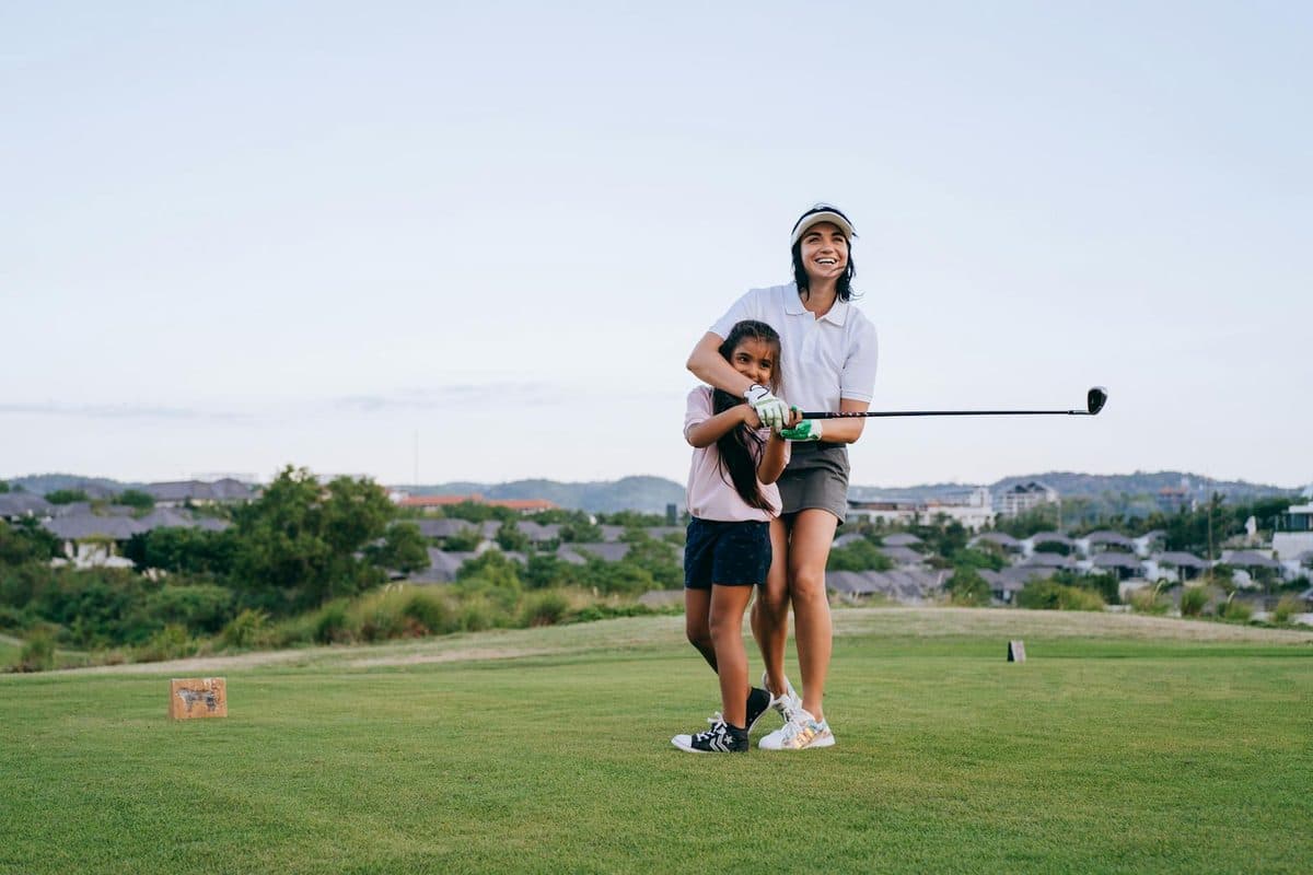 Beginner golfer taking their first lesson on a driving range
