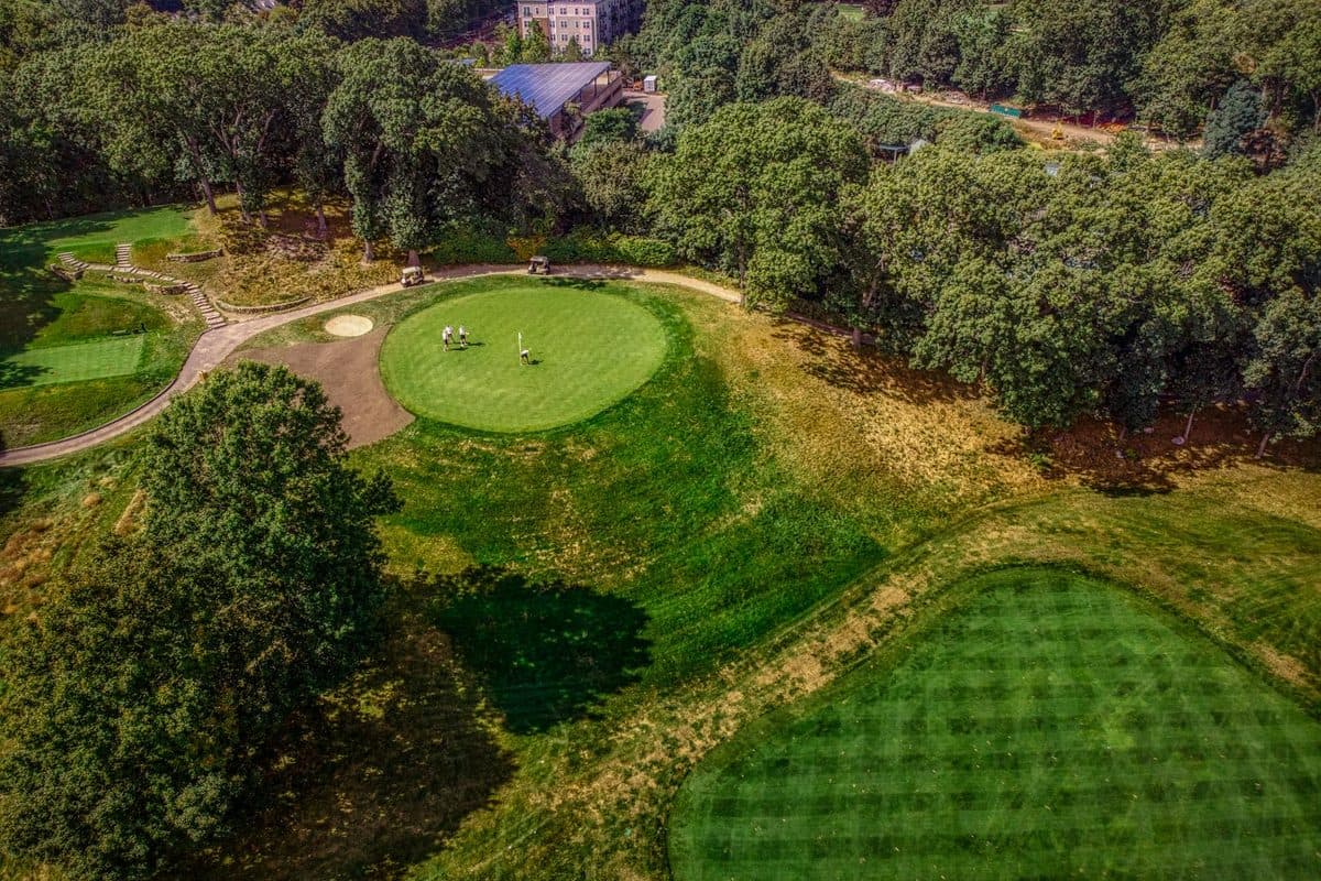 Aerial view of golfers playing on a lush green golf course